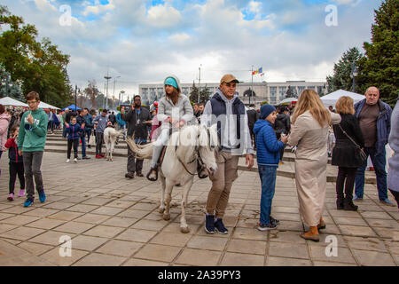 Chisinau, Moldova - October 5, 2019: Young man rides a girl on a pony. Chisinau is the capital of Moldova. A holiday in the park is the central part o Stock Photo