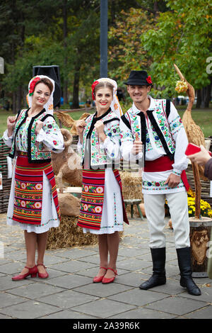 Chisinau, Moldova - October 5, 2019: Two young women and one men in traditional Balkanic costumes at a festival in Chisinau, the capital of Moldova. R Stock Photo