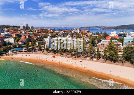 Smooth water surface of Pacific ocean rolling to clean sand of Manly beach on Northern beaches of Sydney - elevated aerial panorama with view to Sydne Stock Photo