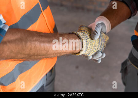 cropped view of constructor shaking hands with architect Stock Photo