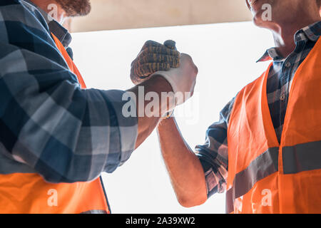 cropped view of constructor shaking hands with coworker Stock Photo