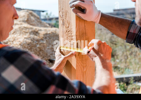 https://l450v.alamy.com/450v/2a39xya/cropped-view-of-middle-aged-man-holding-measuring-tape-near-coworker-2a39xya.jpg