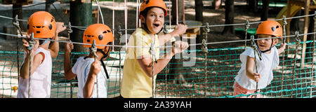 panoramic shot of surprised boy near cute multicultural friends in helmets Stock Photo
