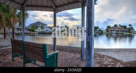 Bench overlooking Savage Pass, which flows under Savage Bridge, at the entrance of Marco Island, Naples, Florida Stock Photo