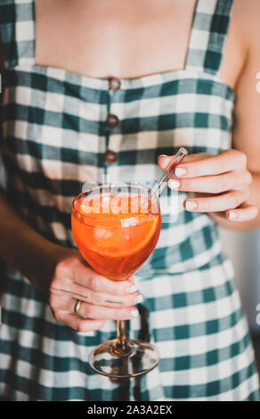 Young woman holding glass of Aperol spritz cocktail in glass Stock Photo