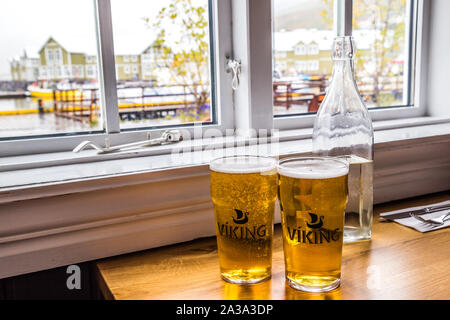 Two viking beers with a view of the marina in Siglufjordur, Iceland Stock Photo