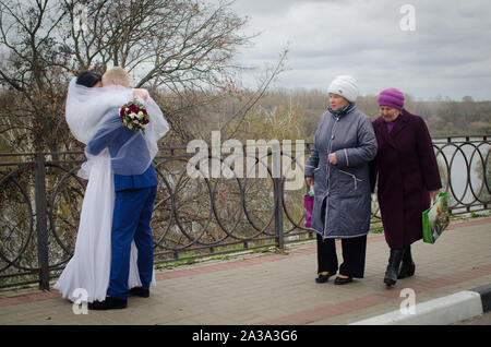Tambov, Tambov region, Russia. 7th Oct, 2019. Autumn wedding. In the photo - elderly woman looking at the kissing couple in the city of Tambov Credit: Demian Stringer/ZUMA Wire/Alamy Live News Stock Photo