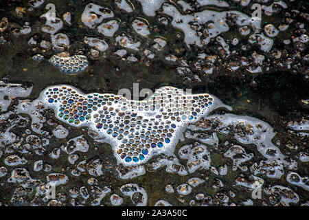close up of iridescent soap bubble pattern on asphalt Stock Photo