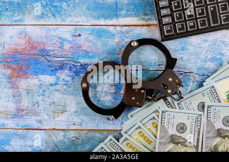 Financial crime accounting, US dollar banknotes money cash corruption money and calculator metal police handcuffs Stock Photo
