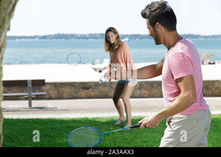 a couple is playing badminton Stock Photo
