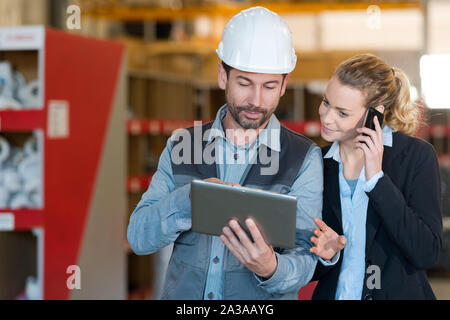 coworkers discussing project by using digital tablet Stock Photo