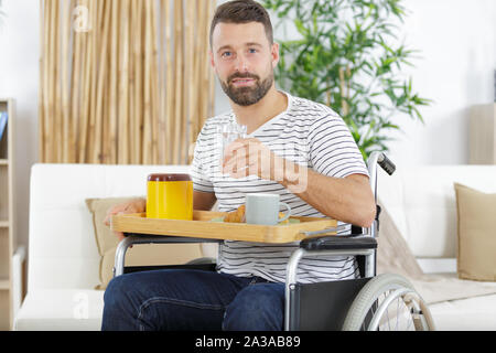 happy disabled man having breakfast in the morning Stock Photo