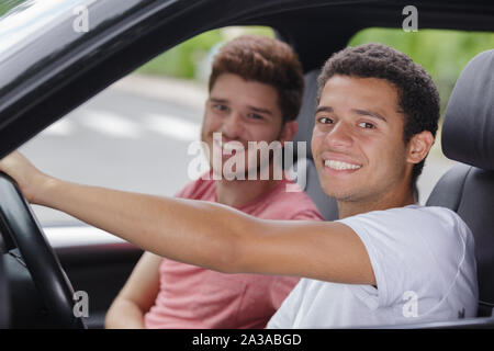 young men behind wheel of new car Stock Photo