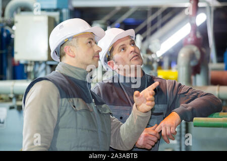 engineer and worker discussing plan of works Stock Photo