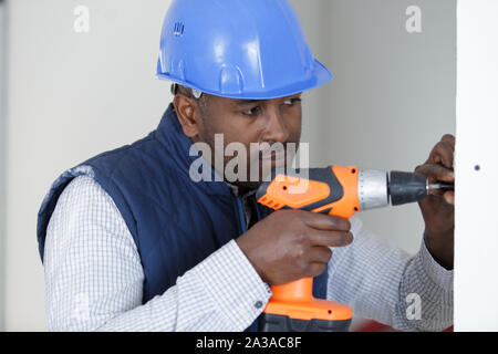 male builder using cordless screwdriver Stock Photo