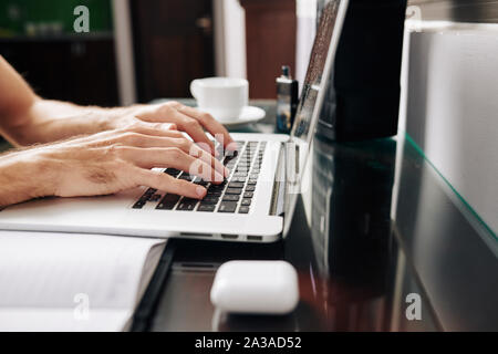 Hands of male programming student working on laptop at his desk Stock Photo