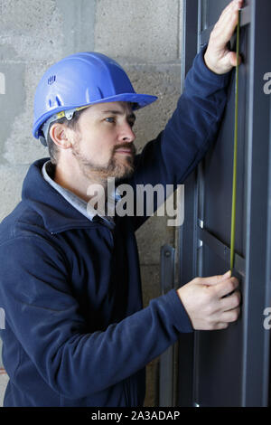 man measuring window prior to installation Stock Photo