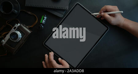 Top view of young man working on his project with tablet in dark luxury workspace Stock Photo