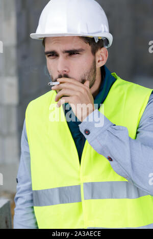 builder smoking cigarette in construction site Stock Photo - Alamy