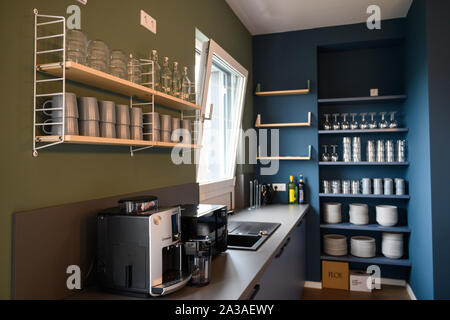 Berlin, Germany. 01st Oct, 2019. In a so-called community room in a newly built residential quarter of the WG provider Medici Living under the brand 'Quarters', crockery stands on a shelf. The provider is presenting 94 new premium flats for young and well-earning professionals. (to 'Senate Administration: Co-Living hardly influences Berlin housing market') Credit: Christophe Gateau/dpa/Alamy Live News Stock Photo