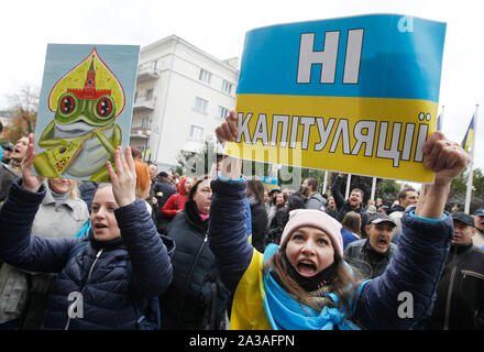 Kiev, Ukraine. 06th Oct, 2019. A woman holds a placard that says, No to capitulationa! while shouting slogans during a rally against approval of the so called Steinmeier Formula.On 01 October the Trilateral Contact Group (TGC) on Ukraine approved a peace process known as so-called Steinmeier Formula which provides local elections in the East of the country and the order of entry into force of the law on the special status of Donbas region, according to media. The Steinmeier's formula is named after Frank Walter Steinmeier, the incumbent president of Germany, former German Foreign Minister. Stock Photo