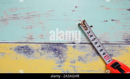 A measuring tape with centimeter unit, on a vibrant wooden background. Stock Photo