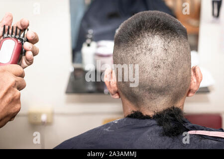 The Crew Cut hairstyle. Short and Easy hair for men. barber making haircut of man in barbershop. Stock Photo