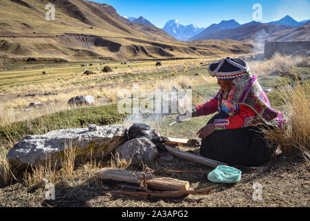 A Quechua lady uses natural dyeing techiques to color Alpaca Wool for textile making. Chillca, Cusco, Peru Stock Photo
