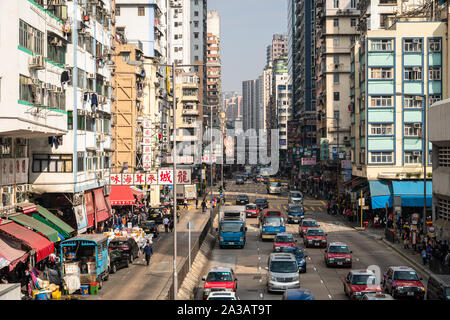 Hong Kong, China - January 27 2019: Cars and buses drive along a street of Mong Kok in Kowloon, Hong Kong Stock Photo