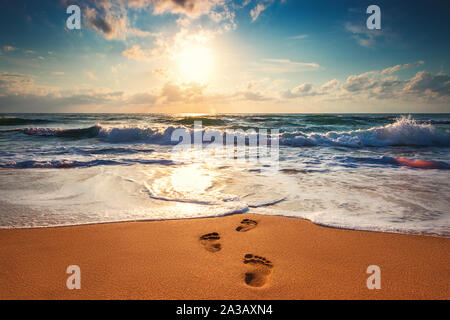 Footsteps on the beach,  sunrise shot. Stock Photo