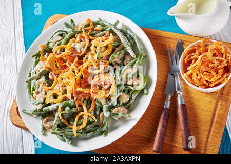 close-up of classic Green Bean Casserole served on a white plate on wooden cutting board, american cuisine, view from above Stock Photo