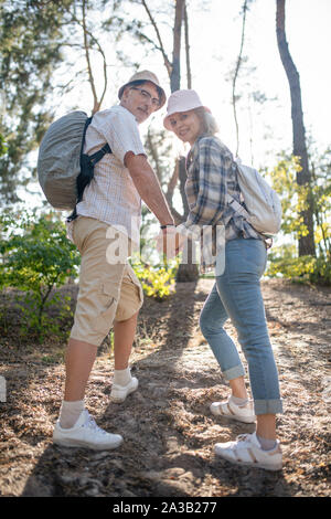 Couple wearing sneakers hiking in forest on nice warm day Stock Photo