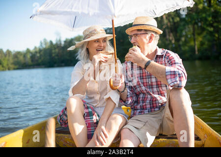 Couple eating sandwiches while having little boat trip Stock Photo