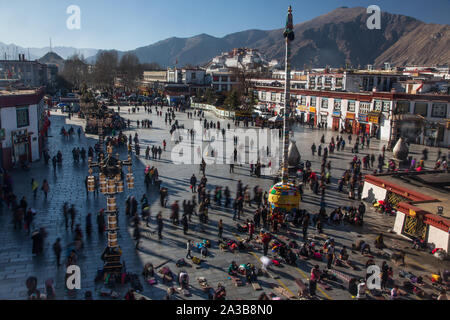 Tibetan pilgrims circumambulate around and prostrate themselves in front of the Jokhang Temple in Barkhor Square in Lhasa, Tibet. Stock Photo