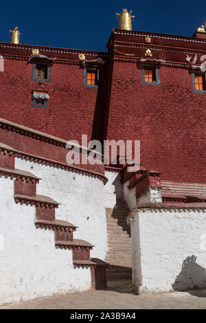 The Ganden Monastery is a Buddhist monastery on Wangbur Mountain in Tibet.  The large red building is the Serdung Lhakhang, a residential building. Stock Photo