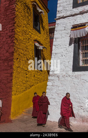 Buddhist monks walking at the Ganden Monastery on Wangbur Mountain in Tibet.  Founded 1409 A.D. but mostly destroyed in 1959 by the Chinese army. Stock Photo