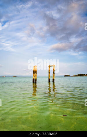 Concrete pillars of an old abandoned jetty on turquoise water beach of an island of Thailand Stock Photo