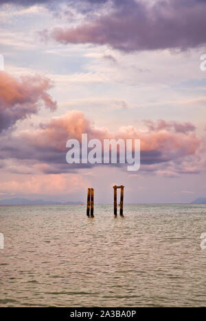 Concrete pillars of an old abandoned jetty on turquoise water beach of an island of Thailand Stock Photo