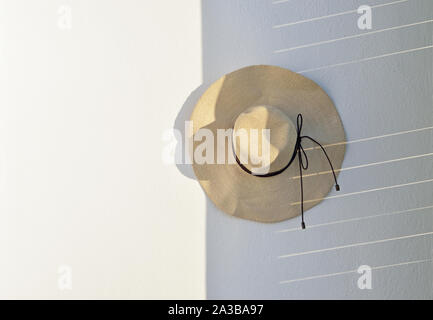 Straw hat hanging on wall Stock Photo