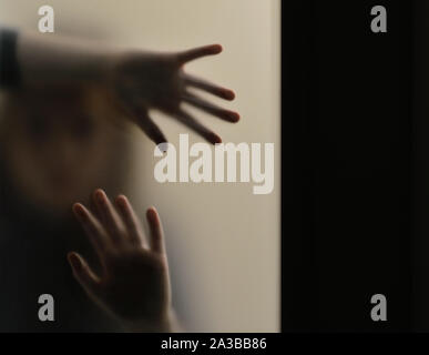 Girl looking behind frosted glass Stock Photo