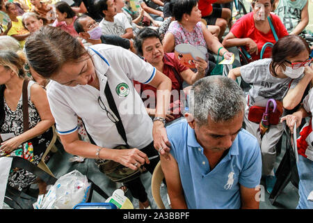 Manila, Philippines. 7th Oct, 2019. An elderly man receives a free vaccine during the mass immunization for senior citizens in Manila, the Philippines, Oct. 7, 2019. The Philippine Department of Health and the local government of Manila vaccinated more than 500 senior citizens against pneumonia and influenza diseases. Credit: Rouelle Umali/Xinhua/Alamy Live News Stock Photo