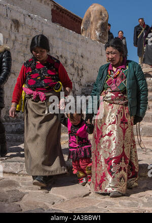 Tibetan women in traditional dress with a child making a pilgrimage to the Potala Palace in Lhasa, Tibet. Stock Photo