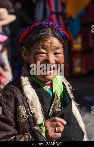 An older woman from the mountains of eastern Tibet in a traditional chupa robe on a pilgrimage to Lhasa, Tibet. Stock Photo