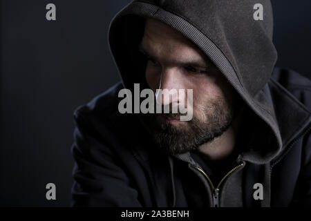 Thoughtful man with hood looking sad. Stock Photo
