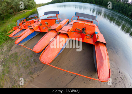 Old orange catamaran on lake. Hipster lifestyle Stock Photo