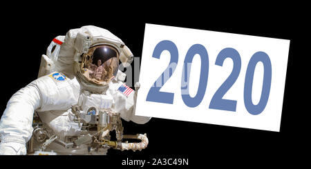Astronaut in space holding a 2020 white  board - New year greeting card - elements of this image are provided by NASA Stock Photo