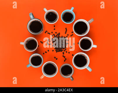 Americano in the different cups on the bright orange background. Flat Lay, cheerful day concept. This image could be used to show coffee break time or Stock Photo