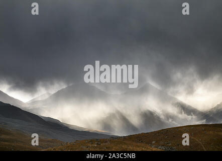 Landscape of Tian Shan Mountains at dark dramatic stormy sky at sunset in Kazakhstan Stock Photo