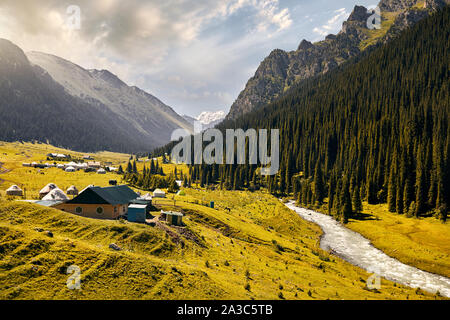 Arashan river and guest houses with yurt in the mountain valley of Altyn Arashan gorge, Kyrgyzstan Stock Photo