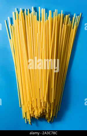 Raw Spaghetti pasta on blue background Stock Photo